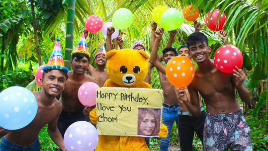 Personalised Bangladesh birthday video greeting energetic dance crew with teddy bear mascot holding personalised birthday message sign with balloons